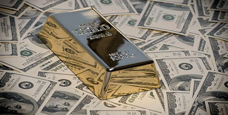 gold brick on top of pile of money