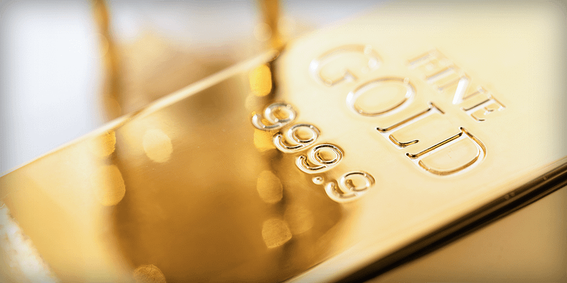 Close-up of stacked gold bar highlighted by warm reflections to convey gold’s liquidity, stability, and enduring value.